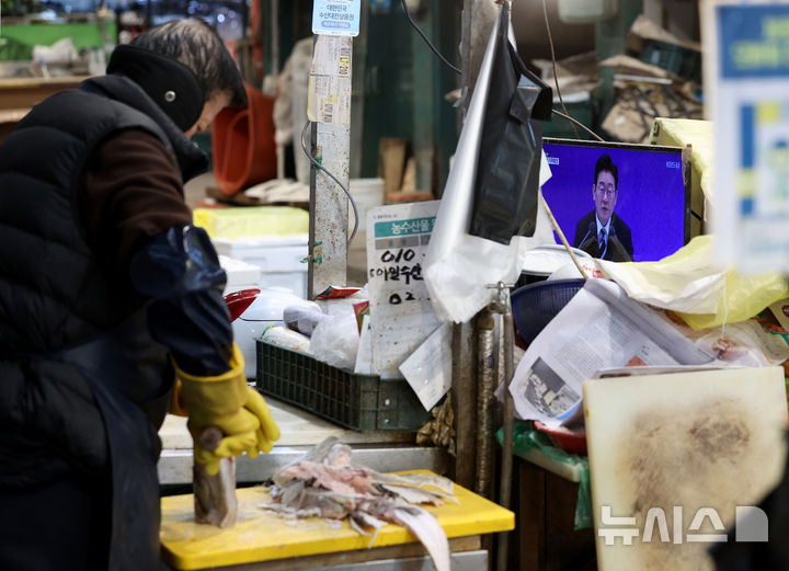 [서울=뉴시스] 김진아 기자 = 21일 서울 서대문구 인왕시장의 한 상점에 이재명 대통령의 신년 기자회견이 TV를 통해 생중계 되고 있다. 2026.01.21. bluesoda@newsis.com