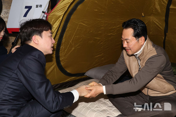 [서울=뉴시스] 고승민 기자 = 장동혁 국민의힘 대표가 21일 오전 서울 여의도 국회 로텐더홀에서 '민주당의 공천 뇌물·통일교 게이트 특검 수용'을 촉구하며 단식농성 중 이준석 개혁신당 대표와 대화를 하며 손을 잡고 있다. (공동취재) 2026.01.21. photo@newsis.com