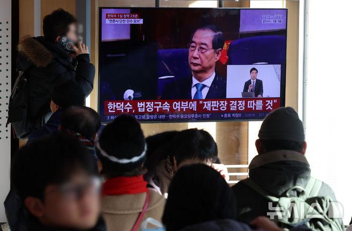 [서울=뉴시스] 조성우 기자 = 한덕수 전 국무총리의 내란 우두머리 방조, 내란 중요임무 종사 혐의 사건 1심 선고 재판이 열린 21일 오후 서울역 대합실에서 시민들이 한 전 총리의 1심 징역 23년 선고 관련 뉴스를 시청하고 있다. 2026.01.21. xconfind@newsis.com