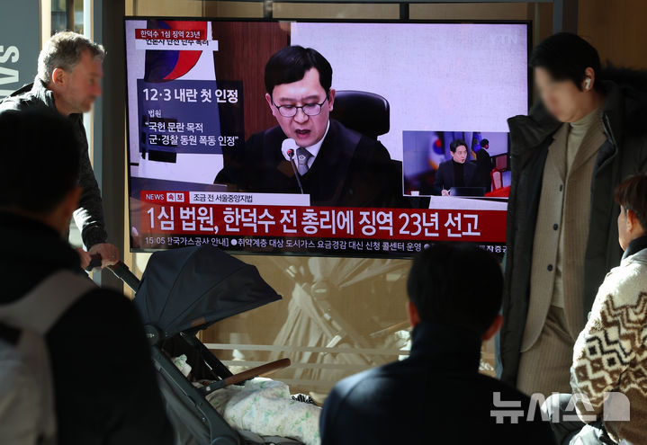 [서울=뉴시스] 조성우 기자 = 한덕수 전 국무총리의 내란 우두머리 방조, 내란 중요임무 종사 혐의 사건 1심 선고 재판이 열린 지난 1월21일 오후 서울역 대합실에서 시민들이 한 전 총리의 1심 징역 23년 선고 관련 뉴스를 시청하고 있다. 2026.01.21. xconfind@newsis.com