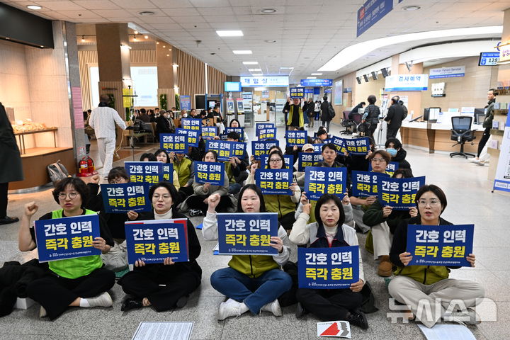 [화순=뉴시스] 이현행 기자 = 민주노총 전국보건의료노조 전남대학교병원지부가 21일 오후 전남 화순전남대병원에서 '인력 축소 철회' 간호사 결의대회를 열고 구호를 외치고 있다. 2026.01.21. lhh@newsis.com