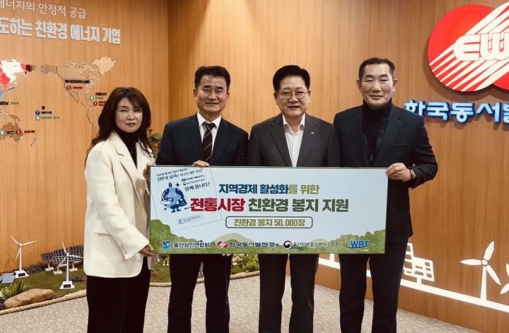 [울산=뉴시스] 22일 한국동서발전 사장실에서 신숙경 화이트 바이오테크 대표, 노형석 울산중소벤처기업청장, 권명호 한국동서발전 사장, 손병길 울산상인연합회장이 전통시장 친환경 봉지를 전달하며 기념사진을 찍고 있다. (사진=한국동서발전 제공) 2026.01.22. photo@newsis.com *재판매 및 DB 금지