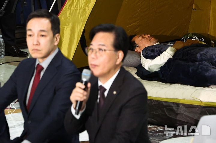[서울=뉴시스] 김명년 기자 = 통일교·공천헌금 '쌍특검' 수용을 촉구하며 여드레째 단식중인 장동혁 국민의힘 대표가 21일 서울 여의도 국회 로텐더홀 농성장 앞에서 열린 최고위원회의에 불참한 채 텐트에 누워있다. 2026.01.22. kmn@newsis.com