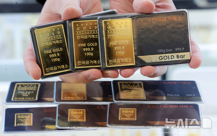 [서울=뉴시스] 홍효식 기자 = 금값이 마침내 '한 돈 100만 원' 선을 넘어선 22일 서울 종로구 한국금거래소 종로본점에서 직원이 골드바를 내보이고 있다. 이날 한국금거래소에 따르면 전일 기준 순금 1돈 매입가는 100만9000원으로 집계됐다. 전 세계적으로 지정학적 불안이 커지는 가운데 그린란드를 둘러싼 미국과 유럽 간 갈등이 급격히 고조되면서 글로벌 금융시장에서 안전자산 선호 심리가 한층 강화된 영향으로 풀이된다. 2026.01.22. yesphoto@newsis.com