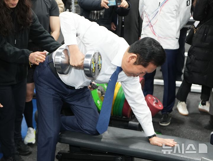 [진천=뉴시스] 정청래 더불어민주당 대표가 23일 충북 진천국가대표선수촌 웨이트트레이닝장을 방문해 선수들을 격려한 뒤 덤벨을 들어올리고 있다. (사진= 공동취재) 2026.01.23. photo@newsis.com 