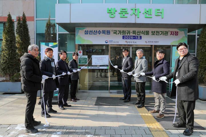 [당진=뉴시스] 국립수목원과 충남 당진시 관계자가 23일 올해 제1호 국가 희귀·특산식물 보전기관으로 지정된 삼선산수목원 방문자센터 앞에서 현판식을 갖고 있다. (사진=당진시 제공) 2026.01.23. photo@newsis.com *재판매 및 DB 금지
