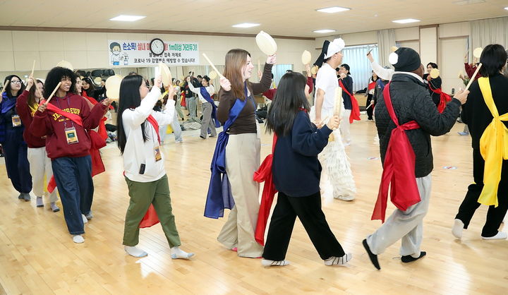 [정읍=뉴시스] 정읍시의 '글로벌 청년 겨울캠프'에 참여한 외국인 유학생과 국내 서포터즈들이 우도농악 소고춤을 체험하고 있다. *재판매 및 DB 금지