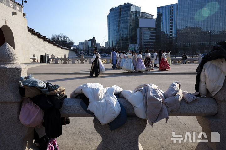 [서울=뉴시스] 정병혁 기자 = 영하권 추운 날씨가 이어진 23일 서울 종로구 경북궁을 찾은 여행객들이 겉옷을 벗고 사진을 찍고 있다. 2026.01.23. jhope@newsis.com