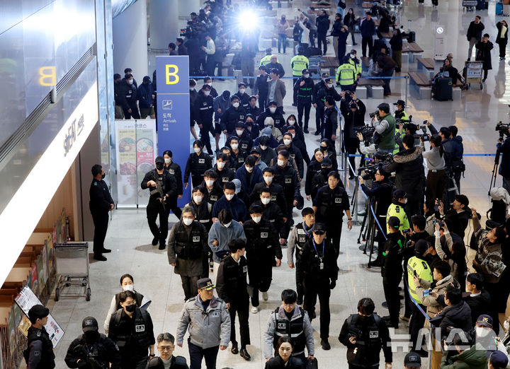 [인천공항=뉴시스] 김진아 기자 = 한국 국적 캄보디아 스캠조직 피의자들이 23일 오전 인천국제공항 제2터미널을 통해 강제 송환되고 있다. 초국가범죄 특별대응 TF는 캄보디아를 거점으로 우리 국민 869명에게 약 486억원을 편취한 한국 국적 피의자 73명을 강제 송환했다. 2026.01.23. bluesoda@newsis.com