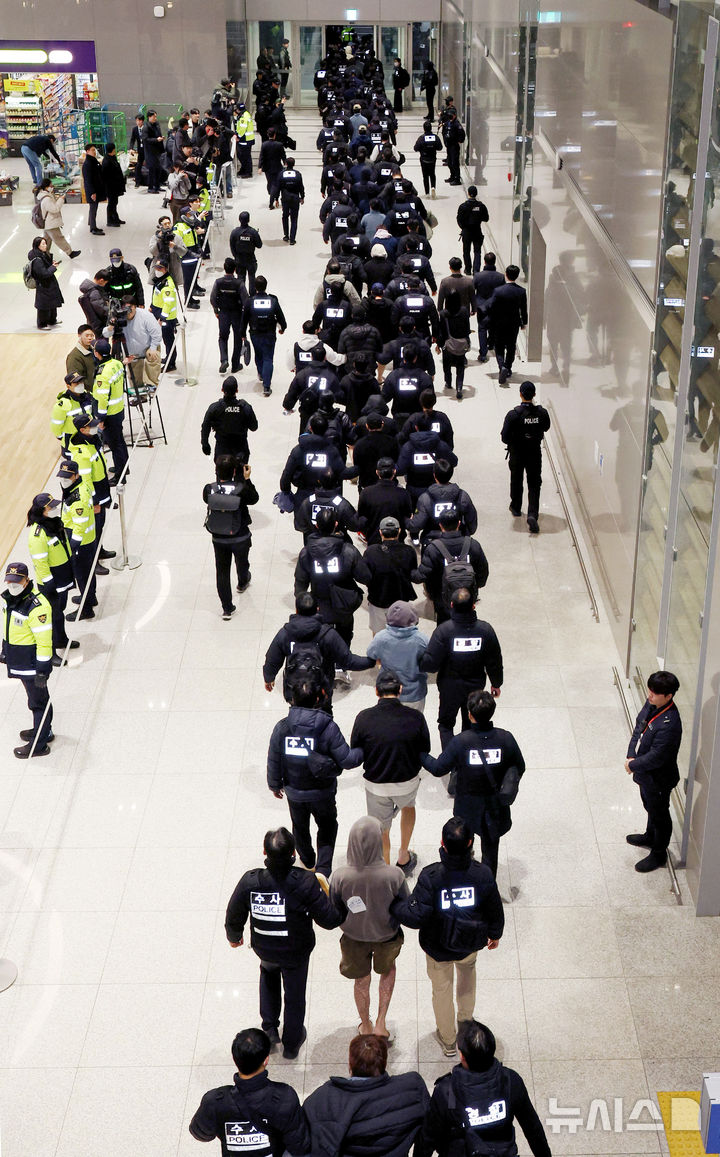 [인천공항=뉴시스] 김진아 기자 = 한국 국적 캄보디아 스캠조직 피의자들이 23일 오전 인천국제공항 제2터미널을 통해 강제 송환되고 있다.&nbsp; 초국가범죄 특별대응 TF는 캄보디아를 거점으로 우리 국민 869명에게 약 486억원을 편취한 한국 국적 피의자 73명을 강제 송환했다. 2026.01.23. bluesoda@newsis.com