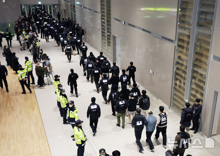 [인천공항=뉴시스] 김진아 기자 = 한국 국적 캄보디아 스캠조직 피의자들이 23일 오전 인천국제공항 제2터미널을 통해 강제 송환되고 있다. 초국가범죄 특별대응 TF는 캄보디아를 거점으로 우리 국민 869명에게 약 486억원을 편취한 한국 국적 피의자 73명을 강제 송환했다. 2026.01.23. bluesoda@newsis.com
