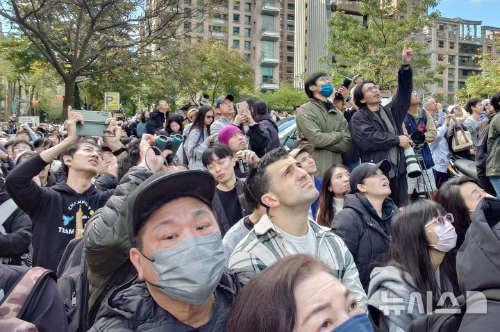 [타이베이=AP/뉴시스] 시민들이 25일(현지 시간) 대만 타이베이 초고층 빌딩 타이베이 101 인근에서 미국의 암벽 등반가 알렉스 호놀드의 등반 모습을 지켜보고 있다. 2026.01.26.