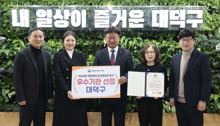 [대전=뉴시스] 조명휘 기자 = 최충규(가운데) 대전 대덕구청장과 직원들이 행정안전부의 '2025 지방세외수입 운영실적 분석·진단' 평가에서 우수기관으로 선정된 뒤 기념 촬영을 하고 있다. (사진= 대덕구 제공) 2026.01.25. photo@newsis.com *재판매 및 DB 금지