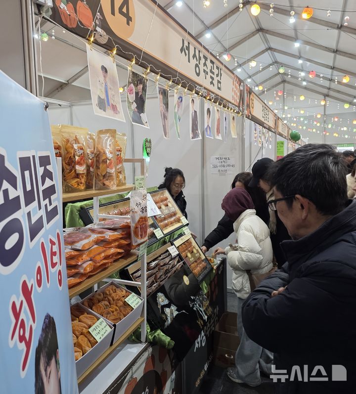 [상주=뉴시스] 박홍식 기자 = '2026 상주곶감축제' 마지막 날인 25일 태평성대 경상감영공원 곶감 판매장을 찾은 시민과 관광객들이 곶감을 맛 보고 있다. 2026.01.25 phs6431@newsis.com