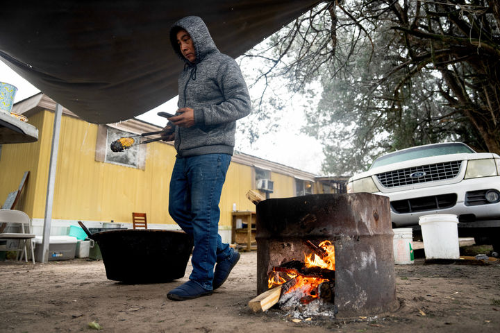 [윌리스=AP/뉴시스] 25일(현지 시간) 미 텍사스주 윌리스에서 북극발 한파로 기온이 영하로 떨어지면서 정전이 발생하자 한 주민이 집 밖 화덕에서 가족이 먹을 음식을 만들고 있다. 강력한 눈 폭풍이 미 남부에서 북동부로 이동하면서 폭설과 결빙으로 인한 대규모 정전 사태와 항공편 결항 등 피해가 속출하고 있다. 2026.01.26.