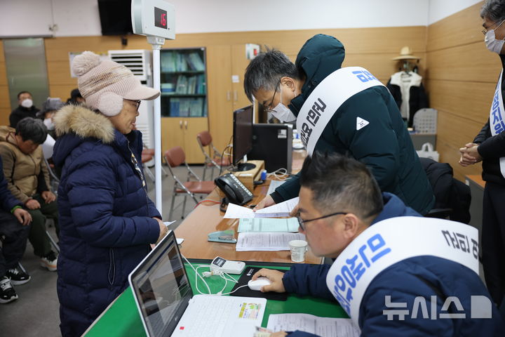 [보은=뉴시스] 연종영 기자 = 26일 충북 보은군 보은읍 행정복지센터에서 직원들이 '민생안정지원금 도우미' 어깨띠를 두르고 민원인들에게 1차 민생안정지원금(30만원)을 담은 선불카드를 지급하고 있다. 보은군은 이날부터 2월27일까지 한달간 군민 3만529명에게 1인당 30만원씩 두 차례 지급한다. 2026.01.26. jyy@newsis.com
