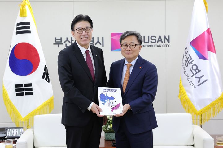 [부산=뉴시스] 박형준 부산시장(왼쪽)이 26일 부산시청에서 전호환 부산-경남 행정통합 공론화위원회 공동위원장으로부터 최종 의견서를 받았다. 기념촬영을 하고 있는 모습. (사진=부산시 제공) 2026.01.26. photo@newsis.com *재판매 및 DB 금지