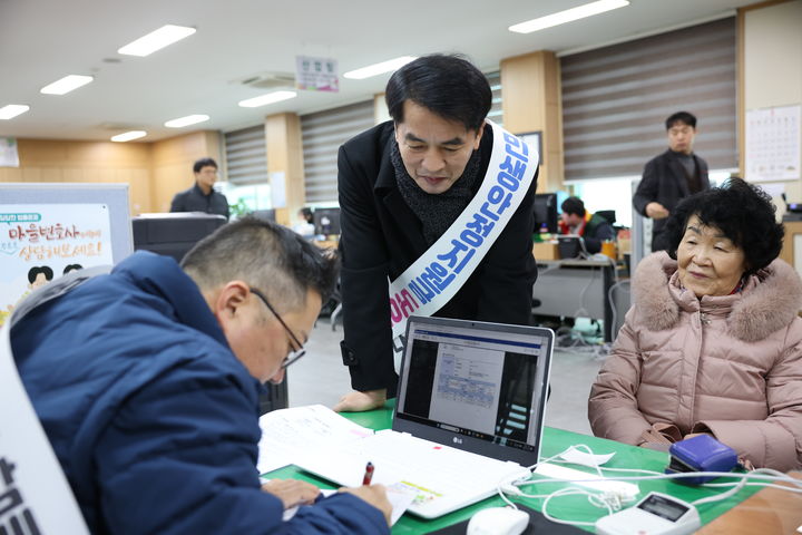 [보은=뉴시스] 충북 보은군이 민생안정지원금 1차분 지급 업무를 시작한 26일 '민생안정지원금 도우미' 어깨띠를 두른 최재형 군수가 보은읍 행정복지센터에서 1차 지원금(30만원) 지급 신청 업무를 돕고 있다. 보은군은 군민 3만529명에게 1인당 30만원씩 두 차례 지급한다. 2026.01.26. jyy@newsis.com *재판매 및 DB 금지
