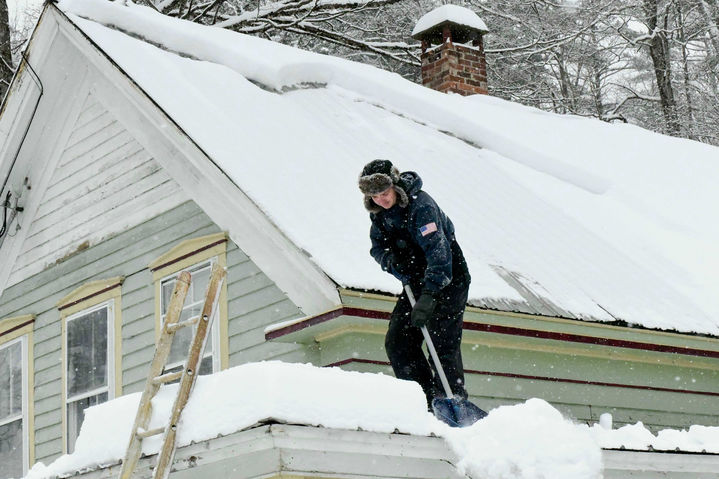 [워즈버러=AP/뉴시스] 26일(현지 시간) 미 버몬트주 워즈버러에서 한 주민이 겨울 폭풍으로 수십 센티미터 눈이 내린 뒤 건물 피해를 막기 위해 지붕의 눈을 치우고 있다. 2026.01.27.