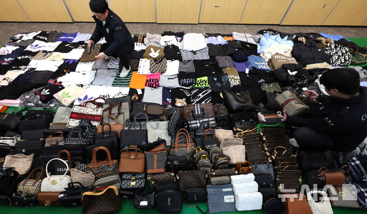 [인천=뉴시스] 전진환 기자 = 27일 오전 인천 중구 관세청 인천본부세관에서 세관 직원들이 위조 명품 온라인 쇼핑몰 운영조직으로부터 압수한 위조 상품을 정리하고 있다.&nbsp; 인천본부세관은 온라인 쇼핑몰을 운영하며, 정품시가 1,200억 원 상당의 가방, 의류, 신발 등 위조 상품 7만 7천여점을 국내로 유통하고 범죄수익 165억 원을 타인 명의로 은닉·세탁한 총책 A씨를 관세법·상표법·범죄수익은닉규제법 위반 혐의로 인천지방검찰청에 구속 송치하고, 관련자 3명은 공모 혐의로 불구속 송치했다고 밝혔다. 2026.01.27. amin2@newsis.com