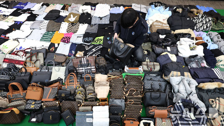 [인천=뉴시스] 전진환 기자 = 27일 오전 인천 중구 관세청 인천본부세관에서 세관 직원들이 위조 명품 온라인 쇼핑몰 운영조직으로부터 압수한 위조 상품을 정리하고 있다.&nbsp; 인천본부세관은 온라인 쇼핑몰을 운영하며, 정품시가 1,200억 원 상당의 가방, 의류, 신발 등 위조 상품 7만 7천여점을 국내로 유통하고 범죄수익 165억 원을 타인 명의로 은닉·세탁한 총책 A씨를 관세법·상표법·범죄수익은닉규제법 위반 혐의로 인천지방검찰청에 구속 송치하고, 관련자 3명은 공모 혐의로 불구속 송치했다고 밝혔다. 2026.01.27. amin2@newsis.com