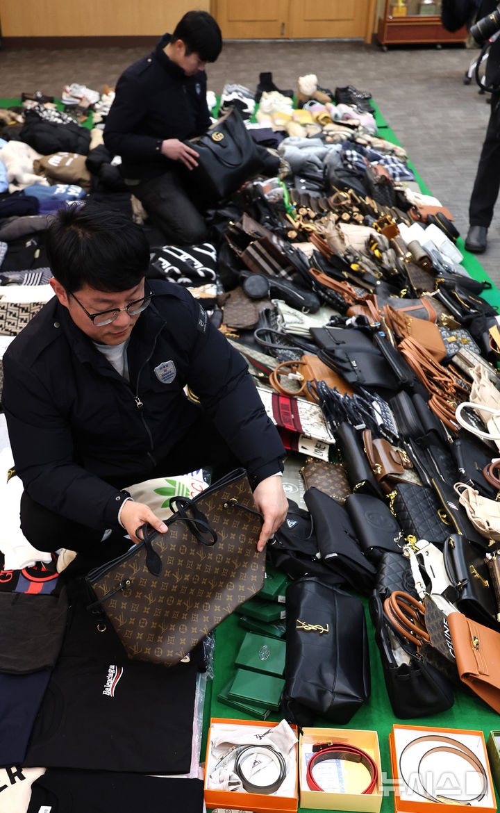 [인천=뉴시스] 전진환 기자 = 27일 오전 인천 중구 관세청 인천본부세관에서 세관 직원들이 위조 명품 온라인 쇼핑몰 운영조직으로부터 압수한 위조 상품을 정리하고 있다.&nbsp; 인천본부세관은 온라인 쇼핑몰을 운영하며, 정품시가 1,200억 원 상당의 가방, 의류, 신발 등 위조 상품 7만 7천여점을 국내로 유통하고 범죄수익 165억 원을 타인 명의로 은닉·세탁한 총책 A씨를 관세법·상표법·범죄수익은닉규제법 위반 혐의로 인천지방검찰청에 구속 송치하고, 관련자 3명은 공모 혐의로 불구속 송치했다고 밝혔다. 2026.01.27. amin2@newsis.com
