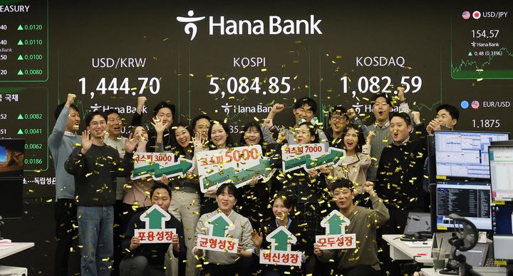[서울=뉴시스] 27일 오후 서울시 중구 하나은행 딜링룸에서 딜러들이 코스피 종가 기준 사상 첫 5000선 돌파를 축하하고 있다. (사진=하나은행 제공) 2026.01.27. photo@newsis.com *재판매 및 DB 금지