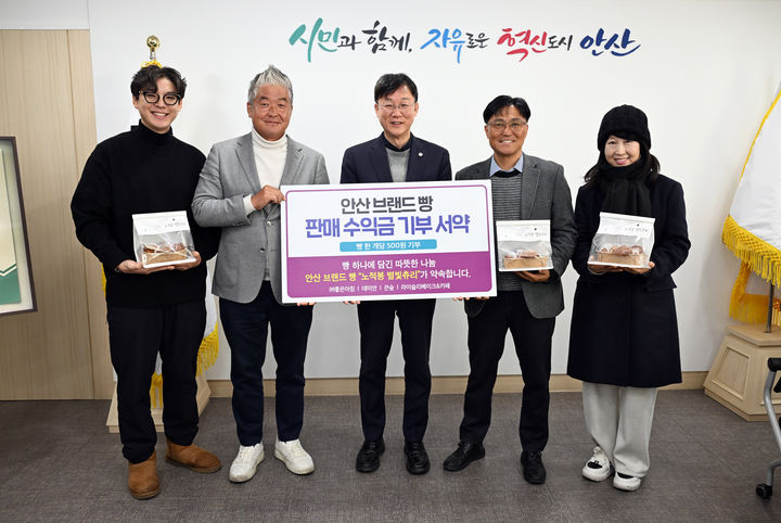 [안산=뉴시스]이민근 안산시장(사진 가운데)이 27일 안산시 브랜드빵 '노적봉 별빛츄리' 판매 수익금 기부 서약식을 마치고 참여자들과 함께 기념촬영을 하고 있다.(사진=안산시 제공)2026.01.28.photo@newsis.com *재판매 및 DB 금지