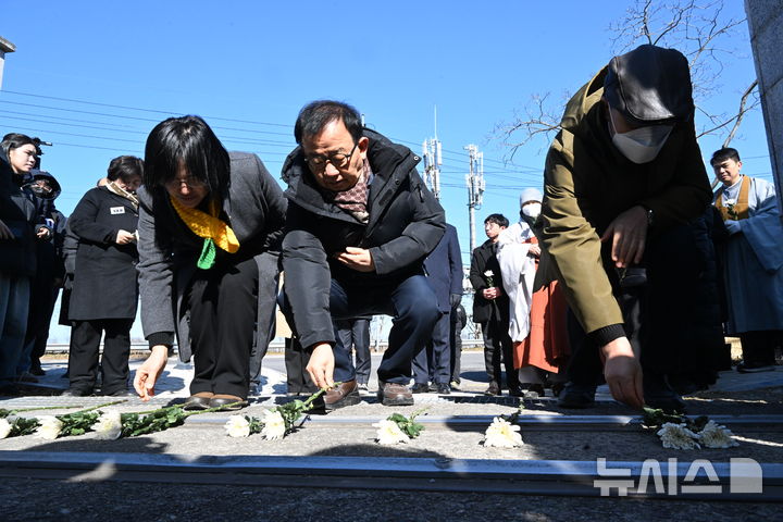 [광주=뉴시스] 이현행 기자 = 4명의 노동자가 숨진 광주대표도서관 붕괴 참사 49일을 맞아 28일 오전 광주 서구 치평동 광주대표도서관 사고 현장에서 '참사 49일 노동자 추모제'가 열린 가운데 참석자들이 사고현장 앞에서 헌화하고 있다. 2026.01.28. photo@newsis.com