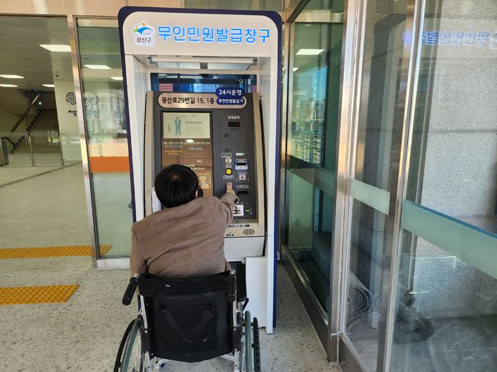 [광주=뉴시스] 광주 광산구는 장애인 접근성 강화를 위해 지역 44곳 45대 무인민원발급기를 개선했다. 휠체어 이용자가 개선된 무인민원발급기를 이용하는 모습. (사진 = 광주 광산구 제공) 2026.01.29. photo@newsis.com *재판매 및 DB 금지
