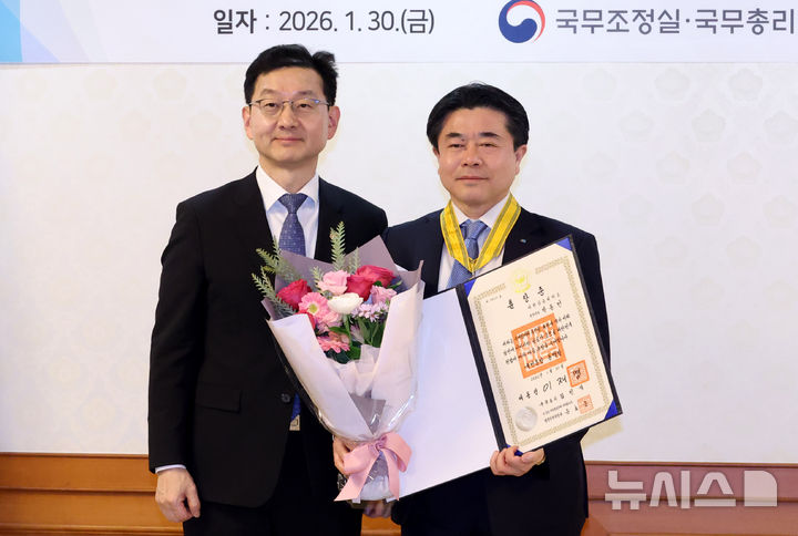 [서울=뉴시스] 추상철 기자 = 윤창렬 국무조정실장이 30일 오전 서울 종로구 정부서울청사에서 열린 규제합리화 유공 정부포상 수여식에서 박동민 대한상공회의소 전무이사에게 국민훈장 동백장을 전달한 후 기념촬영을 하고 있다. 2026.01.30. scchoo@newsis.com