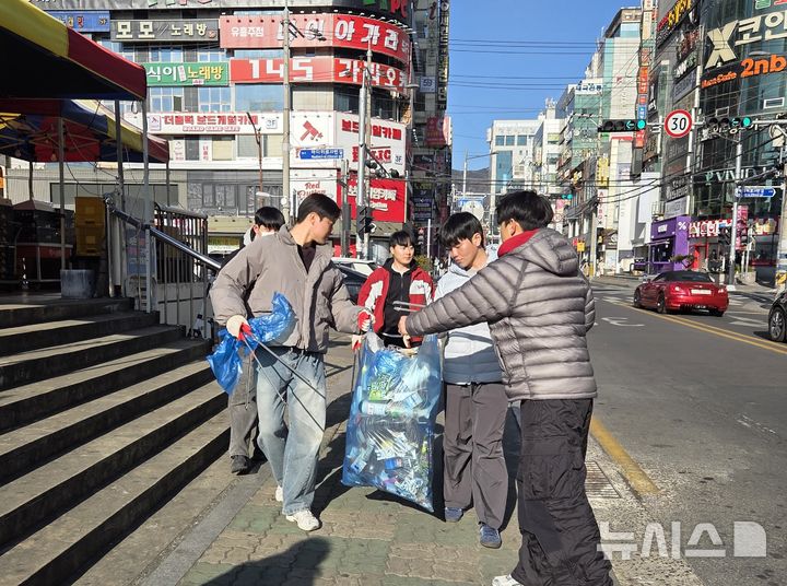 [창원=뉴시스]국민의힘 경남도당 청년위원회 및 대학생위원회 위원들이 31일 창원특례시 성산구 상남동 분수광장에서 공동 발대식을 마친 후 상남시장 일대 환경졍화 활동을 하고 있다.(사진=국민의힘 경남도당 제공) 2026.01.31. photo@newsis.com