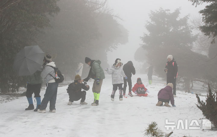 [제주=뉴시스] 우장호 기자 = 제주도 산지에 대설주의보가 내려진 2일 오전 제주시 어승생 삼거리 인근 산록도로변에서 외국인 관광객들이 겨울 정취를 만끽하고 있다. 2026.02.02. woo1223@newsis.com