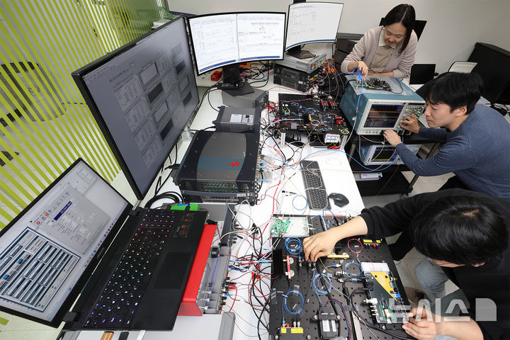 [서울=뉴시스]KT는 초당 30만개(300kbps) 암호키를 생성할 수 있는 양자 암호키 분배 장비를 자체 개발했다고 3일 밝혔다. 사진은 KT 직원들이 양자 암호키 분배 장비를 사용하는 모습. (사진=KT 제공)