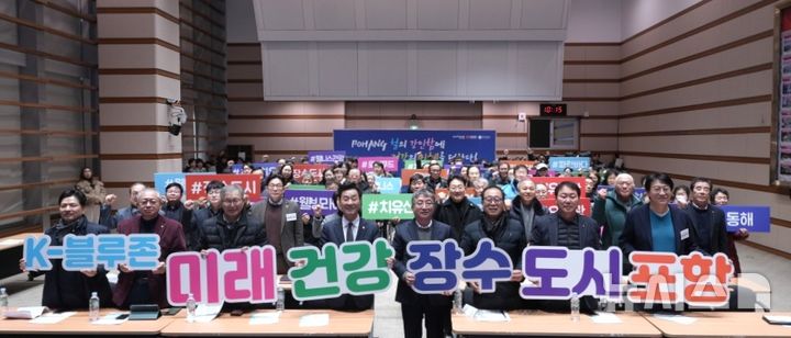 [포항=뉴시스] 송종욱 기자 = 포항시는 3일 시청 대회의실에서 '포항에서 100세 시대의 미래를 연다. K-블루존으로 가는 길 심포지엄'을 개최했다. 사진은 심포지엄 참석자가 '미래 건강 장수 도시 포항' 퍼포먼스를 하는 모습. (사진=포항시 제공) 2026.02.03. photo@newsis.com