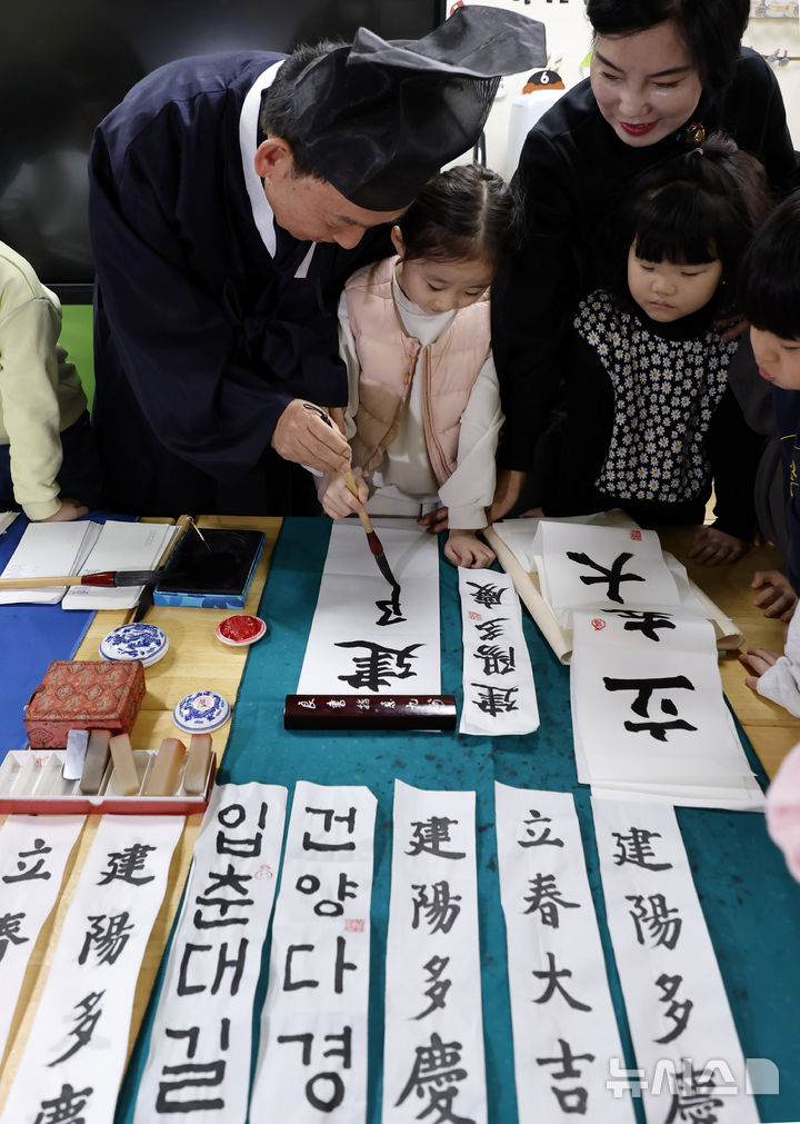 서예가에게 입춘첩 쓰는 법을 배우는 어린이들