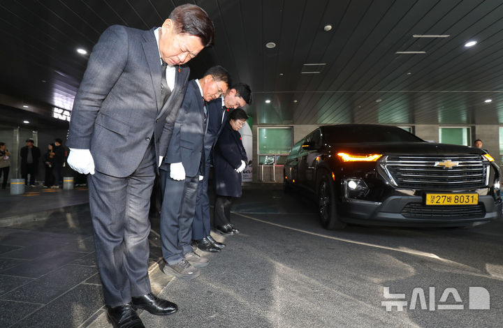 [제주=뉴시스] 우장호 기자 = 오영훈 제주지사가 3일 오후 제주국제공항 1층에서 제주4·3평화교육센터로 향하는 제주4·3 사건 희생자 유해 운구 차량을 향해 인사하고 있다. 이 유해들은 대전 산내 골령골에서 3구, 경산 코발트광산에서 학살된 희생자 유해 중 2구, 제주 도내에서 발견된 유해 2구 신원 등 총 7구이다. 2026.02.03. woo1223@newsis.com