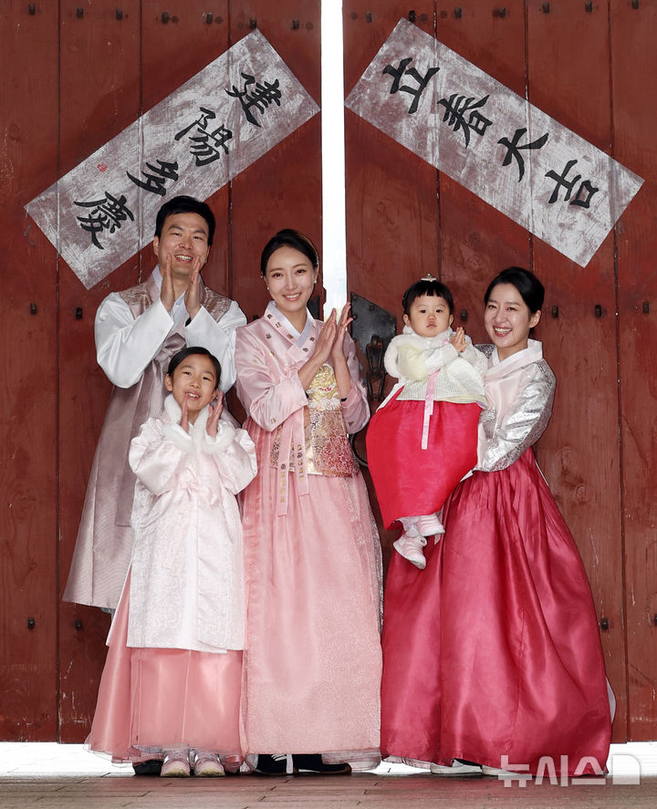 [서울=뉴시스] 조성우 기자 = 절기상 입춘인 4일 오전 서울 중구 남산골한옥마을에서 열린 입춘첩 붙이기 시연 행사에 참여한 1990년생 경오년 말띠인 박민지(오른쪽) 씨와 박은혜 씨가 가족과 함께 '입춘대길·건양다경'이라고 적힌 입춘첩을 붙인 뒤 포즈를 취하고 있다. 2026.02.04. xconfind@newsis.com