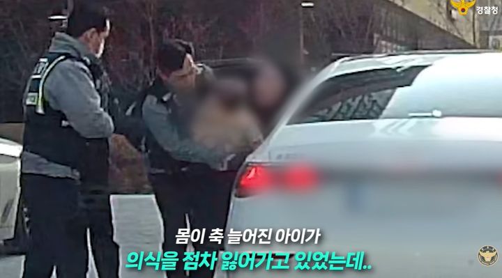 [뉴시스]경찰이 급성 열경련으로 몸이 축 늘어진 아이를 안고 있다. (사진 = 경찰청 유튜브 캡처) *재판매 및 DB 금지