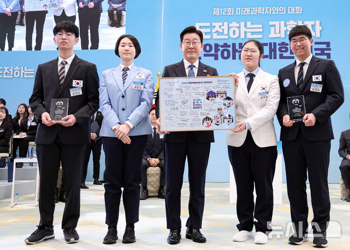 [서울=뉴시스] 고범준 기자 = 이재명 대통령이 5일 청와대에서 열린 대통령과학장학생·올림피아드 대표단 친수 및 간담회(미래 과학자와의 대화)에서 국제과학올림피아드 대표단에게 우리나라 도약을 이끌 미래 과학자로서 다짐을 담은 기념액자 전달을 받은 뒤 함께 기념촬영을 하고 있다. 2026.02.05. bjko@newsis.com