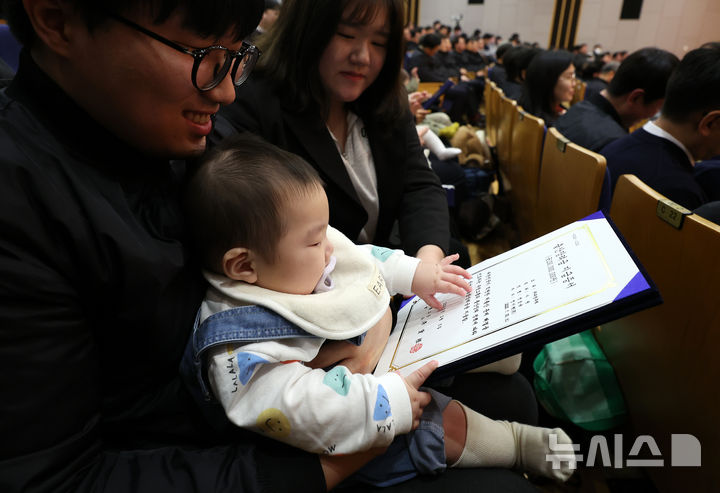[서울=뉴시스] 이영환 기자 = 한 아이가 5일 오전 서울 중구 부영 태평빌딩에서 열린 부영그룹 시무식에 참석해 출산장려금 지급증서를 바라보고 있다. 2026.02.05. 20hwan@newsis.com