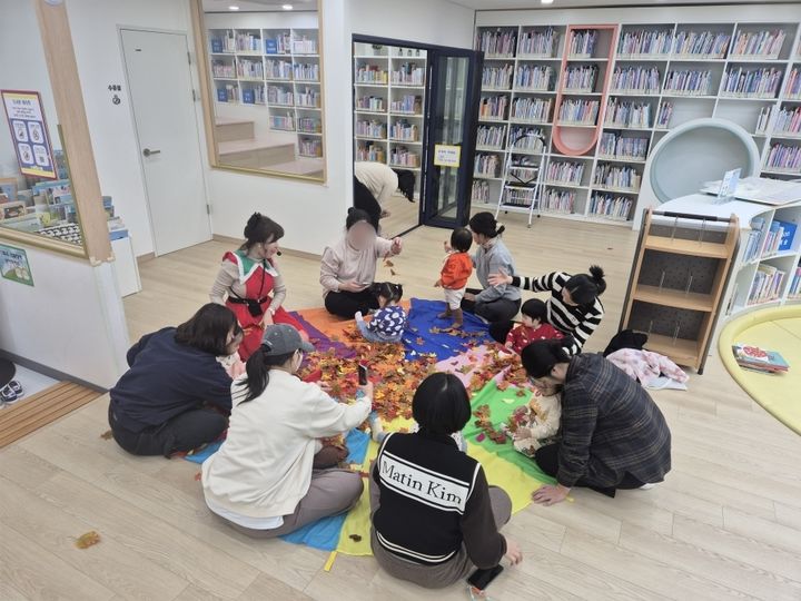 [밀양=뉴시스] 북스타트 부모교육 프로그램에 참여한 영·유아와 양육자가 낙엽놀이 활동을 하고 있다. (사진=밀양시 제공) 2026.02.06. photo@newsis.com *재판매 및 DB 금지