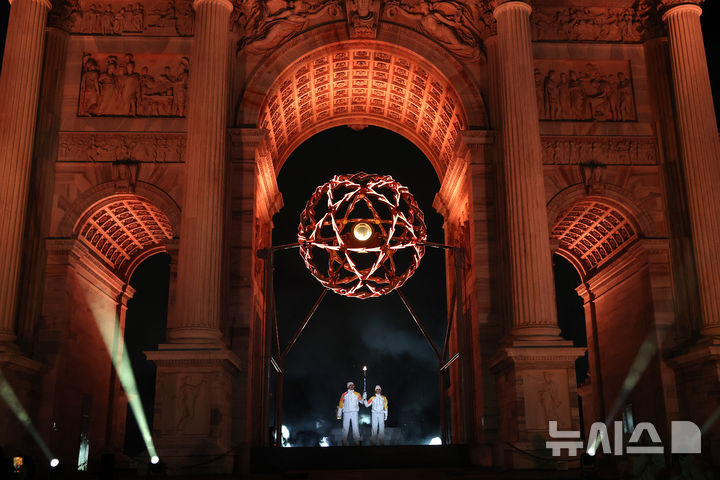 [밀라노=AP/뉴시스]최종 점화자로 등장한 이탈리아 '스키 전설' 알베르토 톰바와 데보라 콤파뇨니. 2026.02.06.