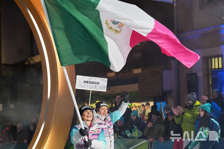 [밀라노=AP/뉴시스]7일(한국시간) 2026 밀라노·코르티나담페초 동계올림픽 공식 홈페이지에 따르면, 멕시코 알파인 스키 여자 국가대표 사라 슐레퍼(47)와 그의 아들인 알파인 스키 남자 국가대표 라세 각시올라(18)가 이번 대회에 동시에 선수로 출전한다. 동계올림픽 모자 출전은 처음이다. 슐레퍼는 개회식에서 멕시코 기수로 나섰다. 