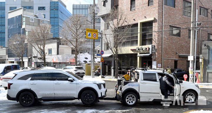 [광주=뉴시스] 이현행 기자 = 광주 지역에 12.5㎝ 적설량을 기록한 8일 오후 광주 동구 서석동 한 거리에서 SUV가 견인되고 있다. 2026.02.08. lhh@newsis.com