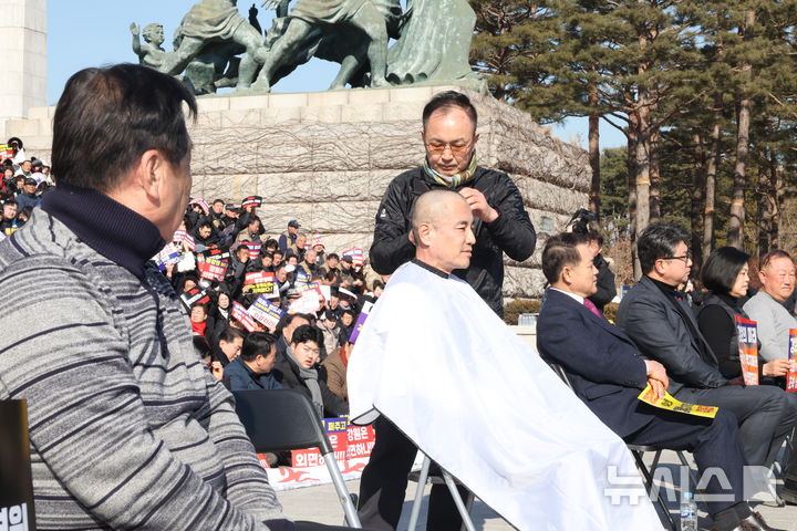 [서울=뉴시스] 조성봉 기자 = 김진태 강원특별자치도 도지사가 9일 오후 서울 여의도 국회 본청 계단에서 열린 ‘강원특별법 3차 개정안의 조속한 입법’ 촉구 대회에서 삭발을 하고 있다.2026.02.09. suncho21@newsis.com 