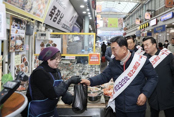 [울산=뉴시스] 김두겸 울산시장이 9일 설 명절을 앞두고 전통시장 물가안정 점검을 위해 수암시장을 방문해 상인들과 시민들을 격려하고 있다. (사진= 울산시 제공) 2026.02.09.photo@newsis.com *재판매 및 DB 금지