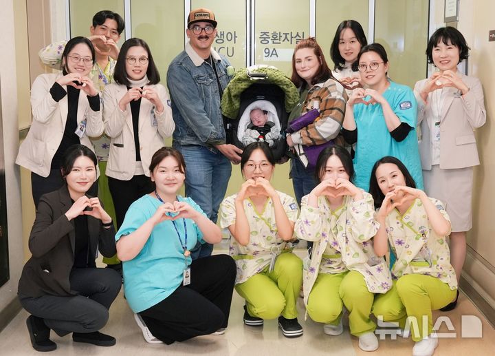 [서울=뉴시스] 서울성모병원에서 임신 6개월에 조기 분만으로 태어나 출생체중 688g에 불과했던 초극소 미숙아 스텟슨(Stetson) 가족이 퇴원을 기념하며 의료진과 사진을 촬영했다. 뒷줄 왼쪽부터 강병수 산부인과 교수, 김세연 소아청소년과 교수(주치의), 스텟슨 가족, 이지연 국제진료센터장(가장 뒷줄 오른쪽) (사진= 서울성모병원 제공) 