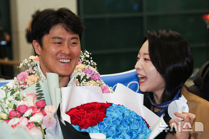[인천공항=뉴시스] 권창회 기자 = 2026 밀라노-코르티나담페초 동계올림픽 스노보드 남자 평행대회에서 은메달을 차지한 김상겸이 10일 인천국제공항 제1여객터미널을 통해 귀국해 아내에게 은메달을 건네주고 있다. 2026.02.10. kch0523@newsis.com