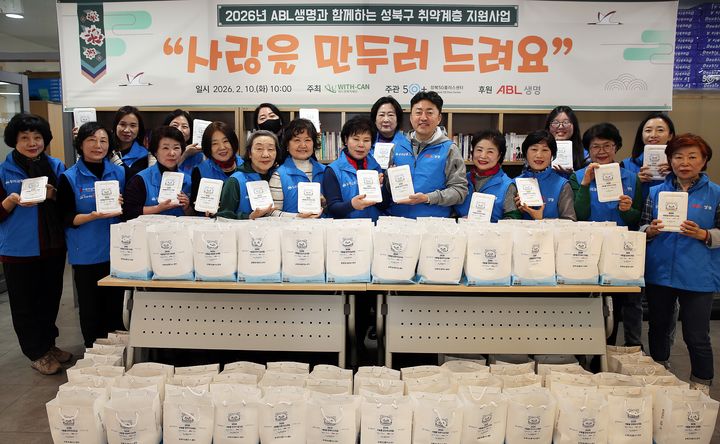 [서울=뉴시스] 지난 10일 서울 성북구 보문동에 위치한 성북50플러스센터에서 ABL생명 FC, FC영업본부 임직원 등 20여명이 만두빚기 봉사활동을 진행하고 기념촬영을 하고 있다. (사진=ABL생명 제공) 2026.02.11. photo@newsis.com *재판매 및 DB 금지